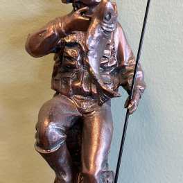 Bronze-colored fisherman figurine holding a fish and fishing rod