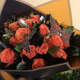 Bouquet of orange roses with butterfly decorations in black and orange wrap