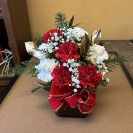 Red and white carnation arrangement in a square vase with a red ribbon