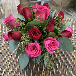 Bouquet of pink and red roses with eucalyptus in a glass vase