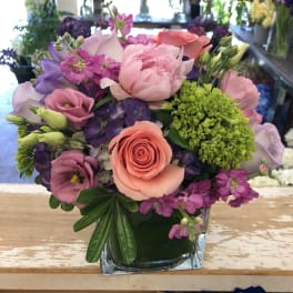 Mixed pink and purple bouquet in a square glass vase