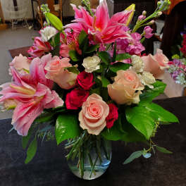 Mixed bouquet of pink lilies and roses in a glass vase