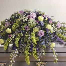 Lavender and green floral casket spray with cascading blooms