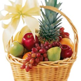 Fruit basket with pineapple, apples, grapes, and a white ribbon bow