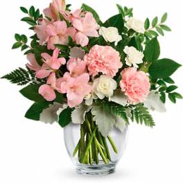 Pink and white flowers arranged in a clear glass vase