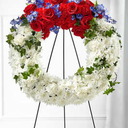 Red, white, and blue floral wreath on a black easel