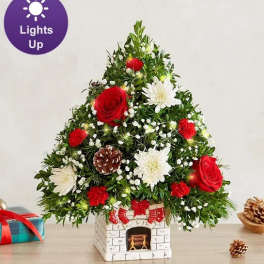 Christmas tree-shaped floral arrangement in a fireplace planter