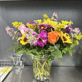 Mixed bouquet of bright flowers in a clear glass vase