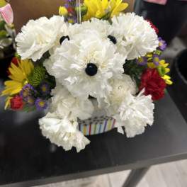 White carnations with colorful daisies in a striped container