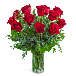 Red roses arranged in a clear glass vase with greenery