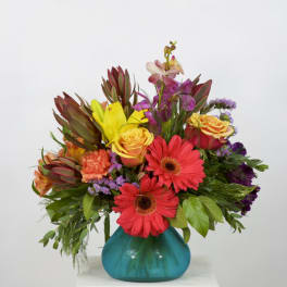 Colorful mixed bouquet in a turquoise glass vase
