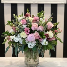 Pink and white floral arrangement in a clear glass vase