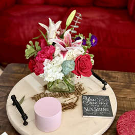 Mixed bouquet with pink roses, white lilies, and hydrangeas in a glass vase
