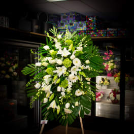 Large white and green standing floral spray on an easel