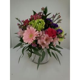 Mixed pink and purple flower arrangement in a silver vase