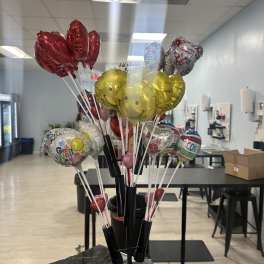 Cluster of helium balloons on sticks in a display stand