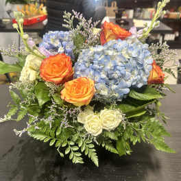 Bouquet of blue hydrangeas and orange roses with white roses