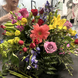Colorful mixed bouquet with roses, lilies, and a pink gerbera daisy