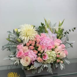 Pink and white floral arrangement in a wooden box