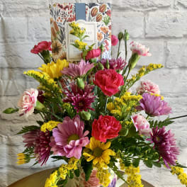 Mixed bouquet of pink, yellow, and purple flowers in a floral vase