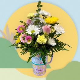 Mixed bouquet in a decorated travel mug with pink, yellow, and white flowers