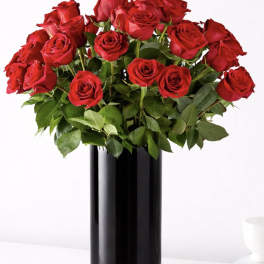 Red roses arranged in a tall black vase