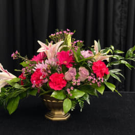 Pink and white floral arrangement in a gold vase