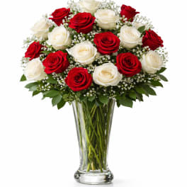 Red and white roses arranged in a clear glass vase