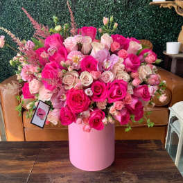 Large pink rose arrangement in a pink cylindrical box