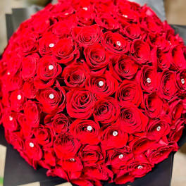 Round bouquet of red roses wrapped in black paper