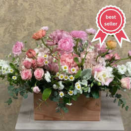Low pink and white flower arrangement with roses and daisies in a wooden box container