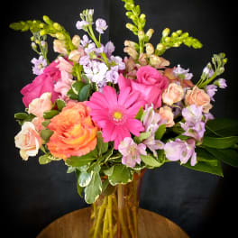 Mixed pink and peach flowers in a glass vase