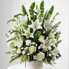 White lilies and roses arranged in a white basket