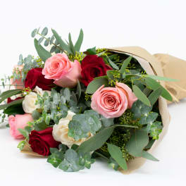 Bouquet of pink, red, and white roses wrapped in paper
