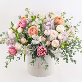Mixed pastel bouquet in a white hatbox-style container