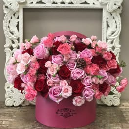 Pink and red roses arranged in a round pink box
