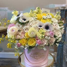 Large pastel flower arrangement in a pink hatbox