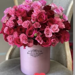 Pink and red roses arranged in a round hatbox