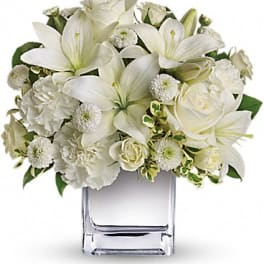 White floral arrangement in a clear square vase