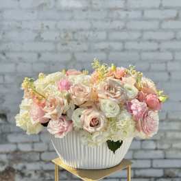 Pastel rose and hydrangea arrangement in a white ribbed bowl