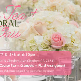 Pastel pink roses and white hydrangeas in low vases on an elegant table with glassware and event text overlay.