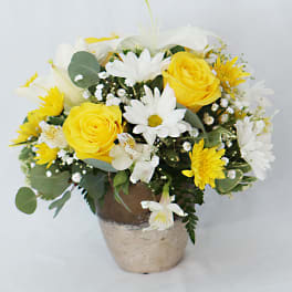 Yellow roses and white daisies in a rustic pot