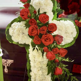 Cross-shaped floral arrangement with red roses and white carnations