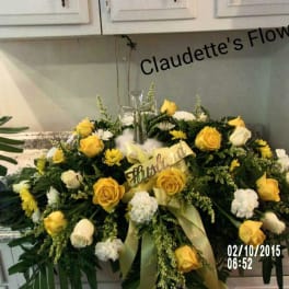Yellow and white rose casket spray with a cross centerpiece