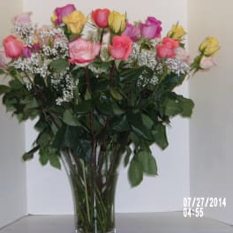Bouquet of pink and yellow roses in a clear glass vase