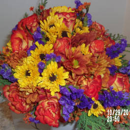 Bright mixed bouquet of red roses, yellow daisies, and purple filler flowers