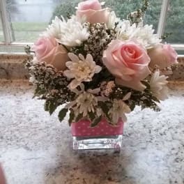 Pink roses and white daisies in a small glass vase