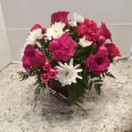 Pink and white flower arrangement in a dark vase
