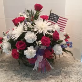 Red, white, and blue floral arrangement with an American flag