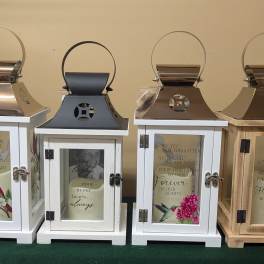 Four memorial lanterns with printed sympathy messages and bird artwork